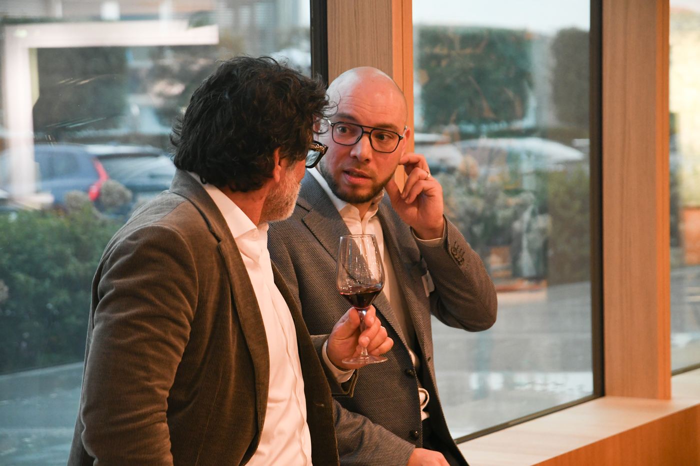 Deux participants en conversation près des baies vitrées, édition #1